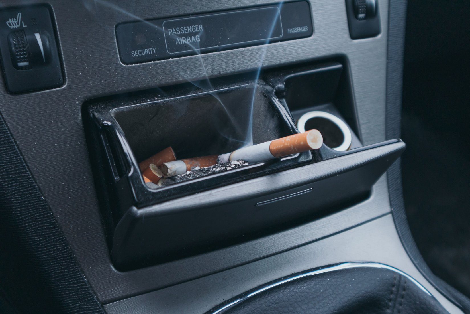 Steaming Cigarette in a Car Ashtray. Smoking in the Car